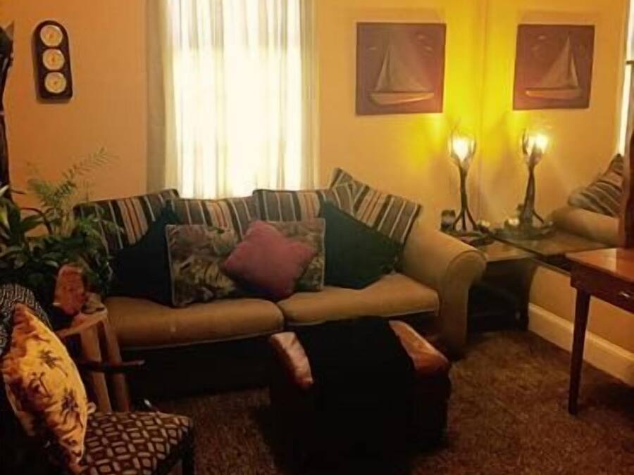 A living room with a sofa, armchair, and a small table.