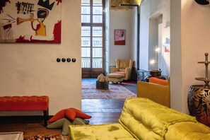 A room with a large window, a sofa, a chair, and a painting on the wall. - PoVenti5 | Art House Torino city center · PoVenti5 | Casa d'arte Torino centro (Torino)
