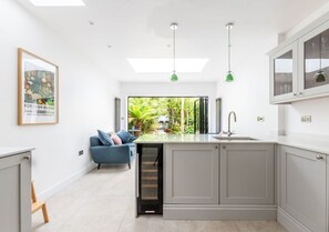 A modern kitchen with grey cabinets, a built-in sink, and pendant lighting. - Luxury 4BR Kingston | London | Villa | Garden Oasis | Free Parking | Near Train (Kingston upon Thames)