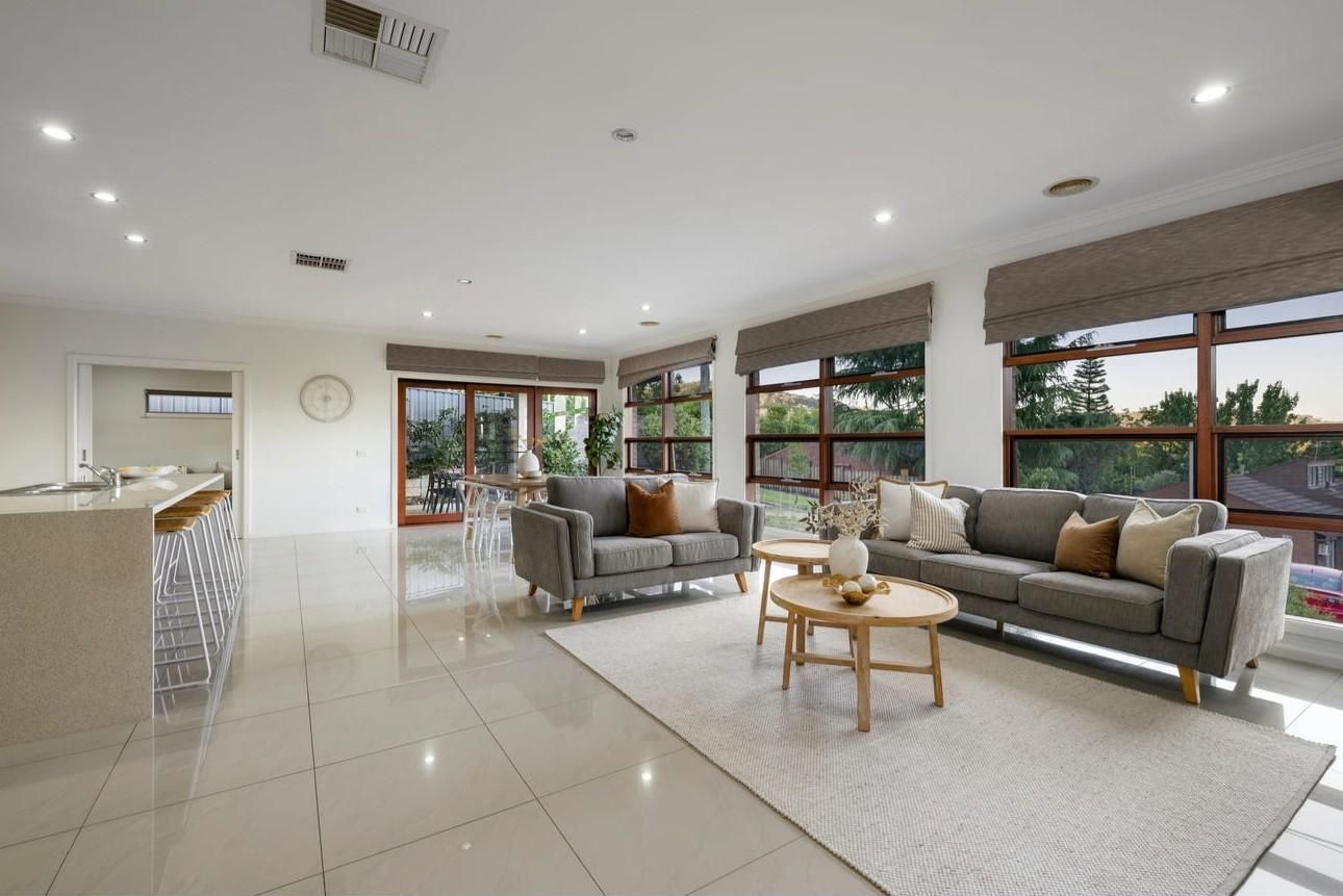 A spacious living area with a sofa, coffee table, and a kitchen area with a bar.