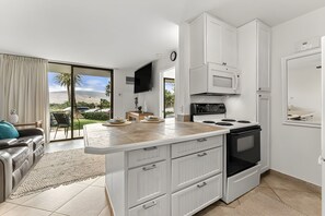 A modern kitchen with white cabinetry, a built-in microwave, and a stove. - Kihei, Kauhale Makai, Spacious 4 BR, Beachfront, Sleeps 12 (Kihei)