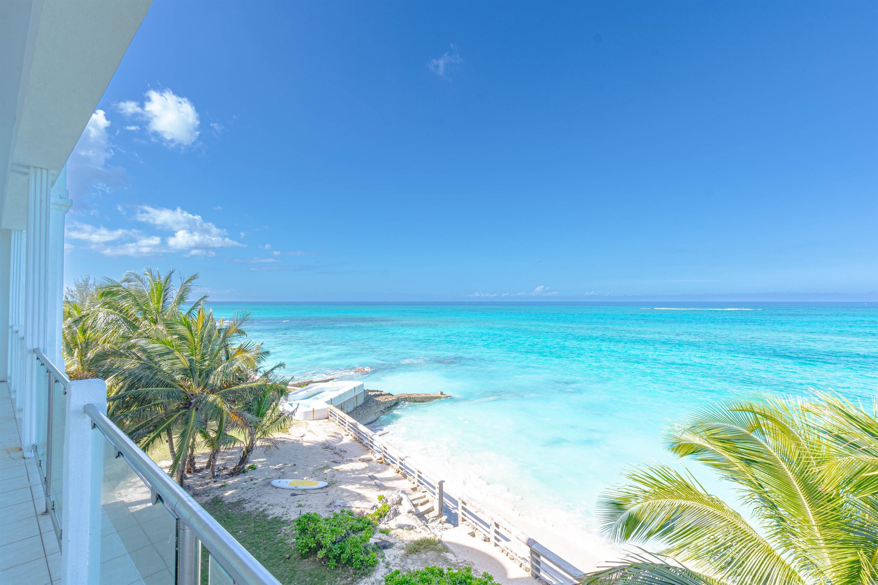 Un balcon avec vue sur une plage et l’océan.
