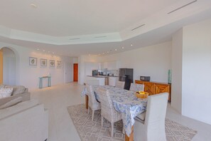 Ein zeitgemäßer Wohnraum mit Essbereich, Küche und einem separaten Zimmer mit Tür zu einem weiteren Bereich.