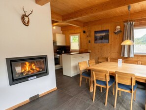 A cozy cabin interior with a fireplace, wooden dining table, and chairs. - Cabin in Annaberg With Swimming Pool (Annaberg-Lungoetz)