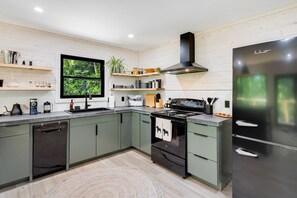 Une cuisine moderne équipée d’un lave-vaisselle, d’une cuisinière et d’un réfrigérateur.