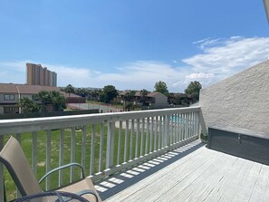 A balcony with a view of a residential area, including houses and a tall building. - Endless Summer - Gulf View - Sleeps 6! (Panama City Beach)