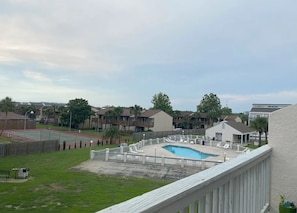 A residential area with a swimming pool, tennis courts, and a fenced deck area. - Endless Summer - Gulf View - Sleeps 6! (Panama City Beach)