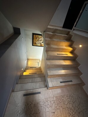 Uma escadaria de design moderno que leva a um patamar com uma obra de arte emoldurada.