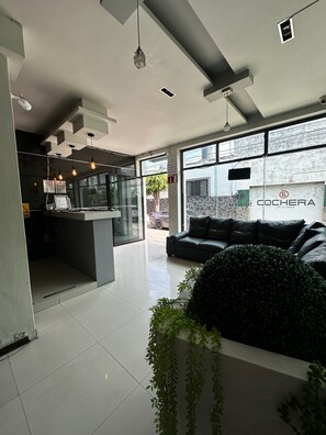 A modern interior with a seating area, a kitchen, and large windows. - Hotel kristal  (La Barca)