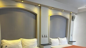 A hotel room with two beds, each with a headboard, a bedside table, and a wall-mounted light. - Hotel kristal (La Barca)