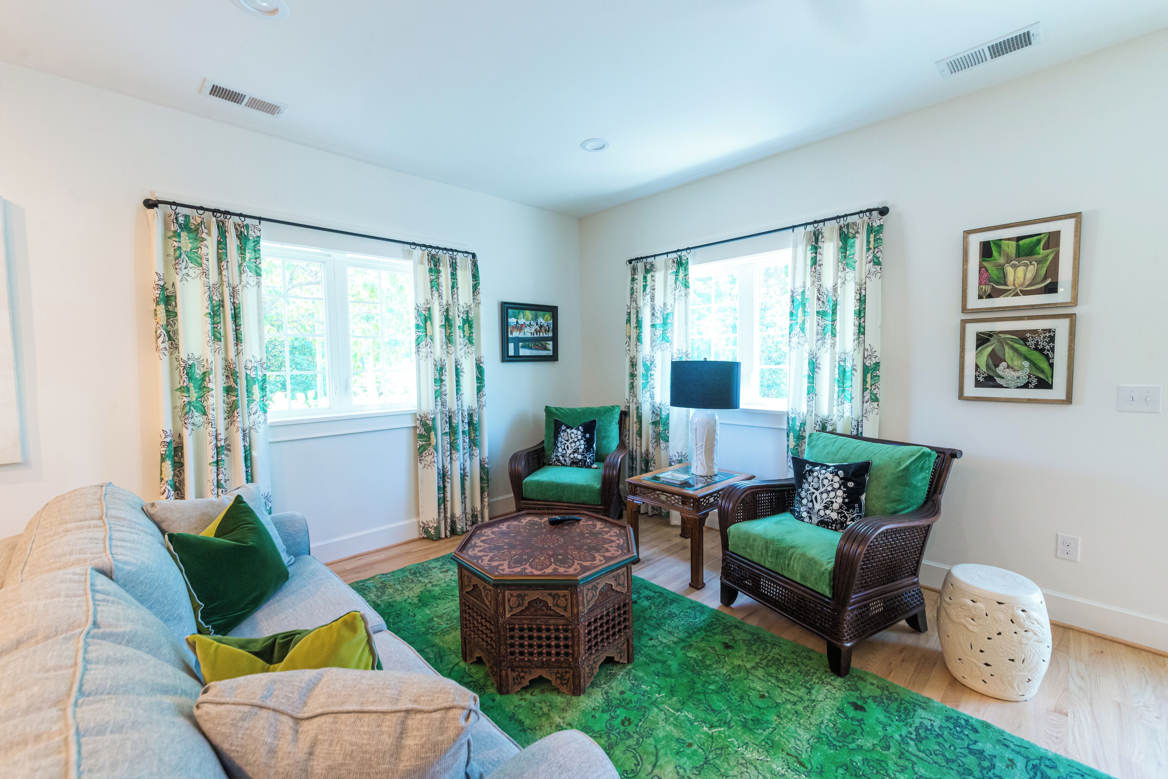 A living room with a sofa, two chairs, a coffee table, and a decorative lamp.