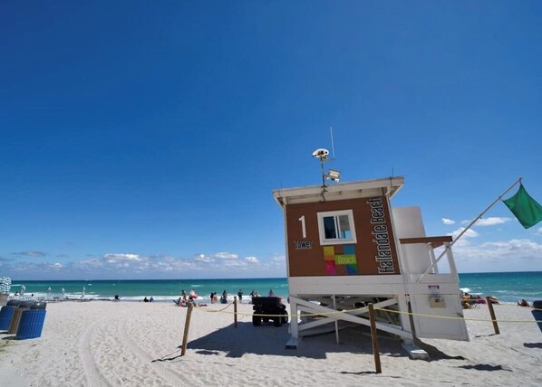 Ein Rettungsturm an einem Strand bei blauem Himmel.