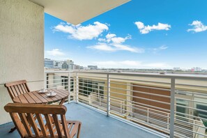 Ein Balkon mit Tisch und Stühlen, einem Geländer und Blick auf die Stadt.