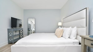 A modern bedroom with a large bed, a TV, a desk, and a mirror. - Cozy Blue Door Duplex, Central in Cutler Bay (Cutler Bay)