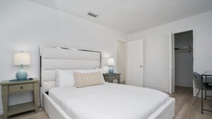 A bedroom with a bed, bedside tables, a desk, and a chair. - Cozy Blue Door Duplex, Central in Cutler Bay (Cutler Bay)
