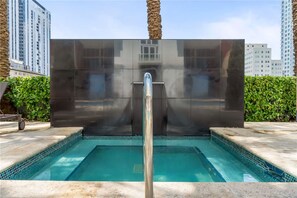 A swimming pool with a modern design, surrounded by a tiled deck and palm trees. - Biscayne Bay Views Studio Central in Miami (Miami)