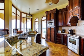 A spacious kitchen with granite countertops, a Bosch oven, and wooden cabinetry. - Villa Castello, Private, Amenities, Walk to Beach (Placencia)