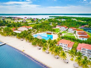 A resort with multiple buildings, a swimming pool, and a beach.