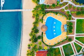 An aerial view of a resort with a central swimming pool, palm trees, and a beach. - Villa Castello, Private, Amenities, Walk to Beach (Placencia)