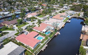 Vista aérea de una zona residencial con casas, un canal y un muelle.
