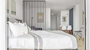 A modern hotel room with a large bed, a desk, two chairs, and a view of the city through the window. - La Marinita, Quaint, Water Views Minutes to Beach (North Bay Village)