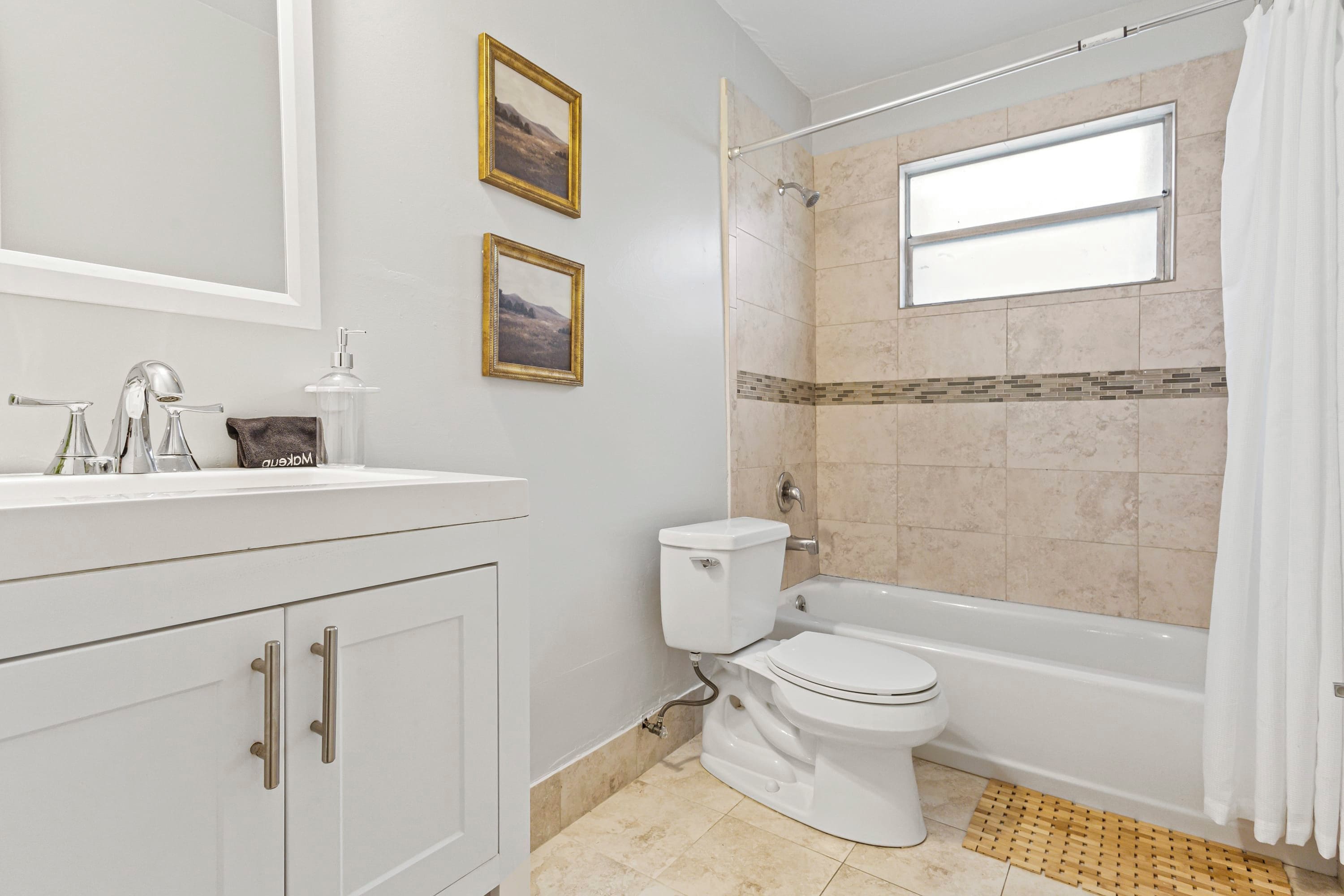 Un baño con tocador blanco, inodoro, bañera y ducha.