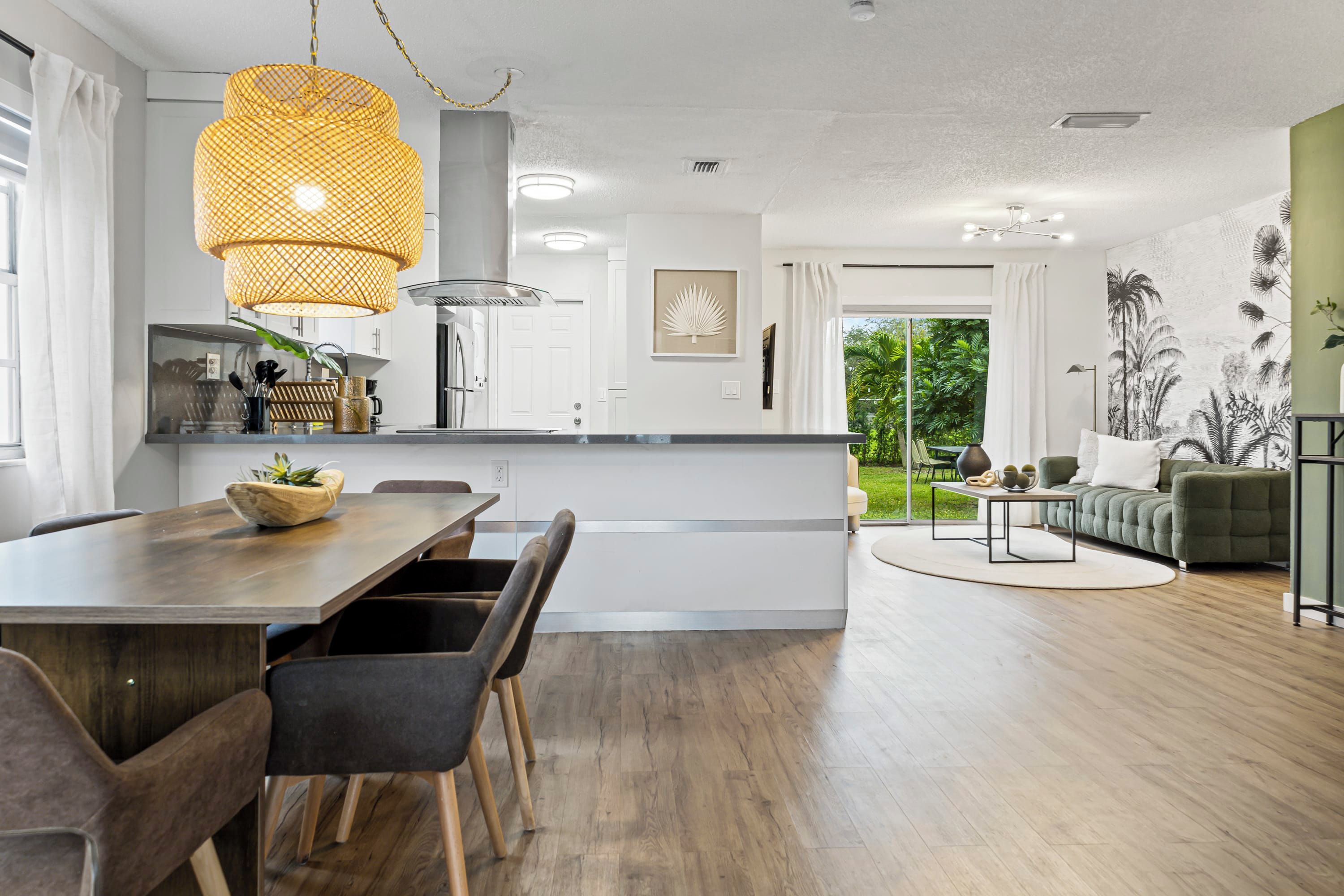 Una cucina moderna con zona pranzo, un'isola grande e vista sull'esterno.