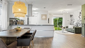 Una cocina moderna con comedor, una isla grande y vistas al exterior.