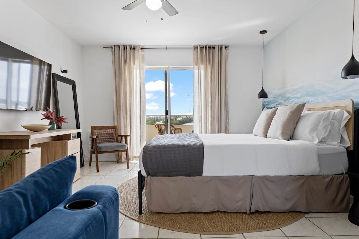 Camera d'albergo con un letto, una scrivania, una sedia, un divano e vista sull'esterno.