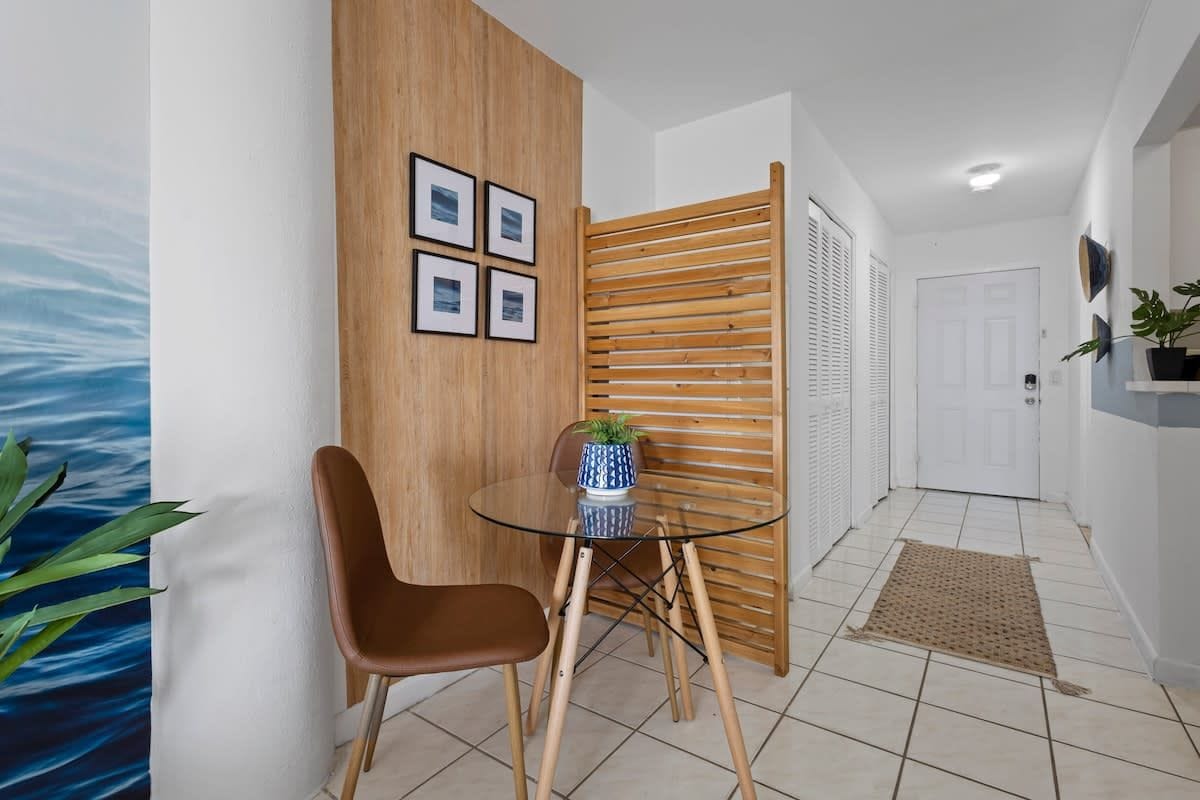 Een modern interieur met een glazen tafel, een wand met houten latten en een deur.