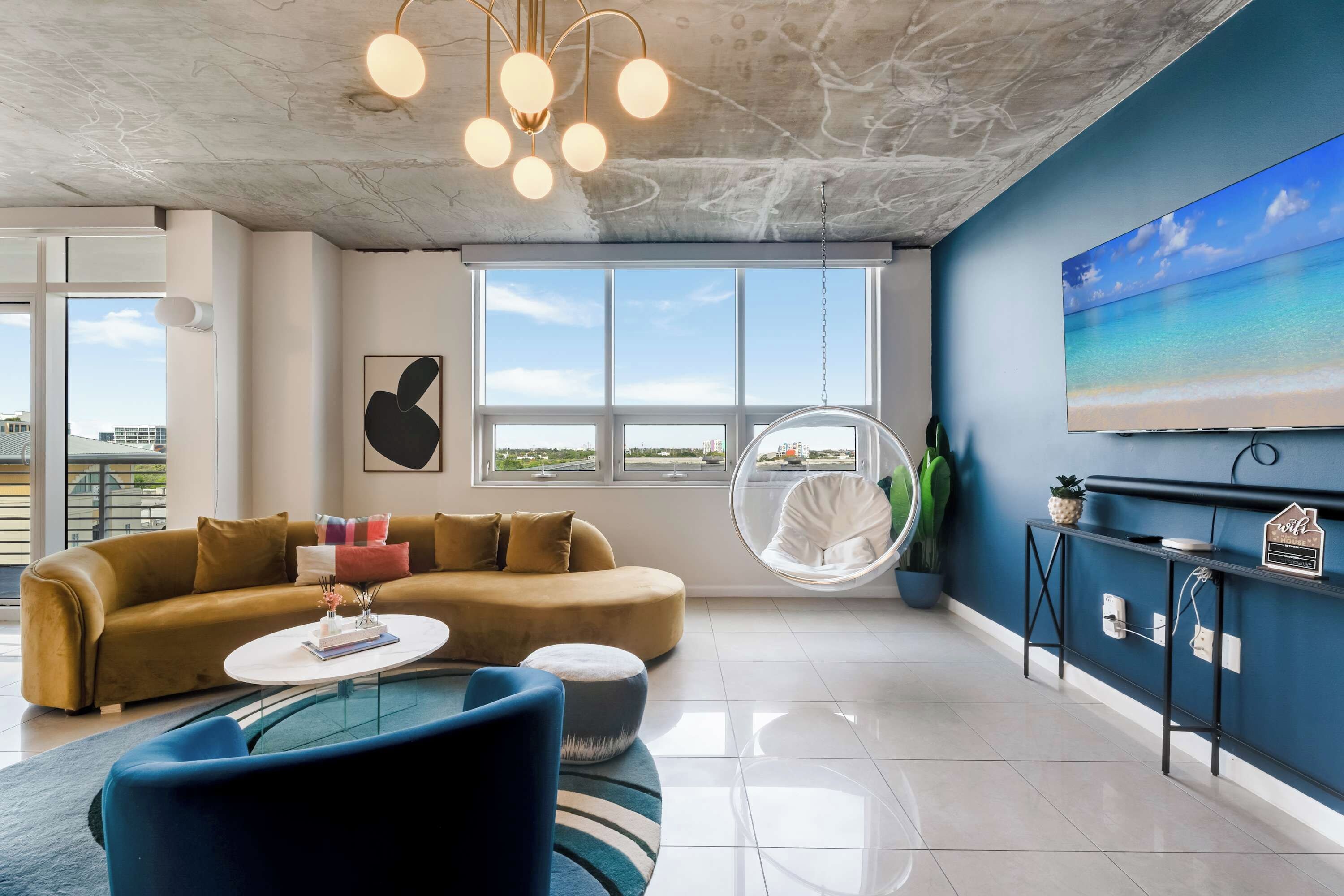 Una sala de estar moderna con un sofá, una mesa de centro y un sillón colgante.
