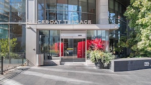 A modern building with a glass entrance, a sign reading 'ICEBOAT TERRACE,' and a potted plant in the foreground. - HarbourtFront Center (Toronto)