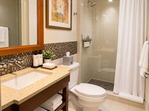 A bathroom with a sink, toilet, and shower area.