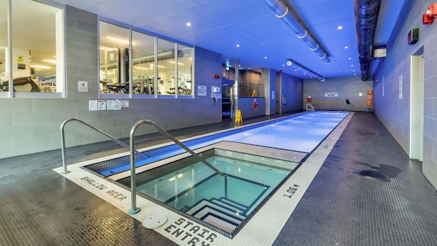 An indoor swimming pool with clear lane markings, a shallow water area, and a no diving sign. - HarbourtFront Center (Toronto)