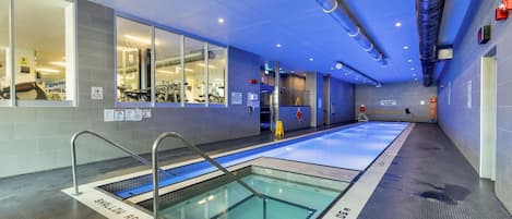 An indoor swimming pool with clear lane markings, a shallow water area, and a no diving sign.