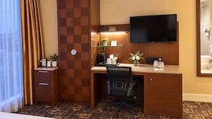 A hotel room with a desk, chair, television, and a bed. - HarbourtFront Center (Toronto)