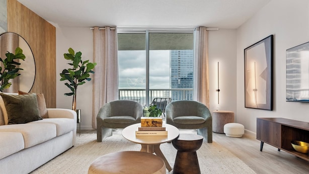 A modern living room with a sofa, two armchairs, a coffee table, and a bookshelf. - Relaxing Cloud 9, Central Brickell Location (Miami)