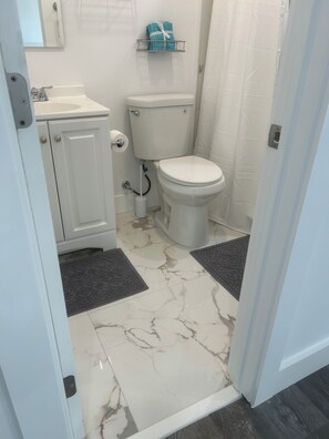 Ein Badezimmer mit Toilette, Waschbecken und Handtuchhalter.