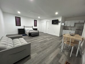 Ein modernes Schlafzimmer mit Bett, Nachttischen, Schreibtisch und Stuhl.