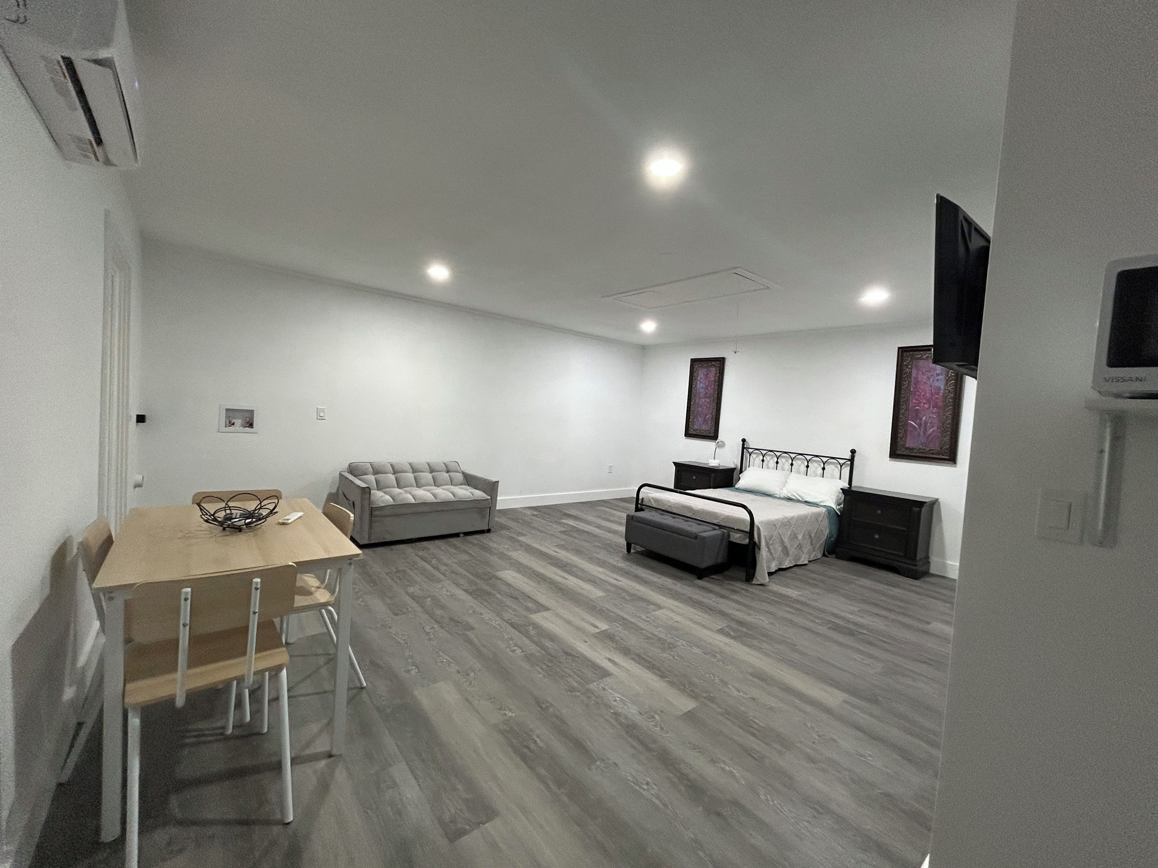 A bedroom with a bed, bedside table, and a TV.