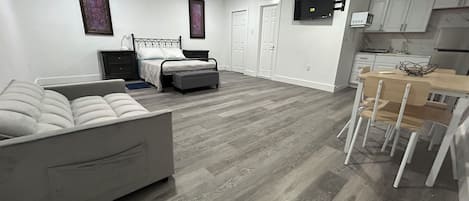 Un dormitorio moderno con una cama grande, mesitas de noche, un escritorio y una silla.