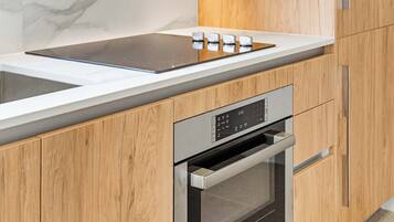 Une cuisine moderne équipée d’un four encastré, d’une plaque de cuisson et d’un four à micro-ondes.