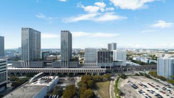 A high-rise urban area with modern buildings, a parking lot, and a bridge.