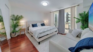A modern bedroom with a large bed, a sofa, and a balcony with a city view. - Brickell Bay View- Unbeatable Location and Parking (Miami)