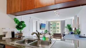 A modern kitchen with granite countertops, stainless steel sink, and wooden cabinets. - Brickell Bay View- Unbeatable Location and Parking (Miami)
