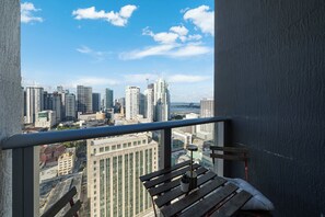 A balcony with a view of a cityscape, including high-rise buildings and a body of water. - Skyline Studio With Rooftop Pool & Parking (Miami)
