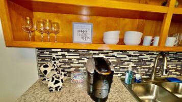 A kitchen with a coffee maker, a sink, and a countertop.