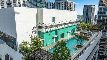A modern building with a rooftop pool, surrounded by high-rise buildings.