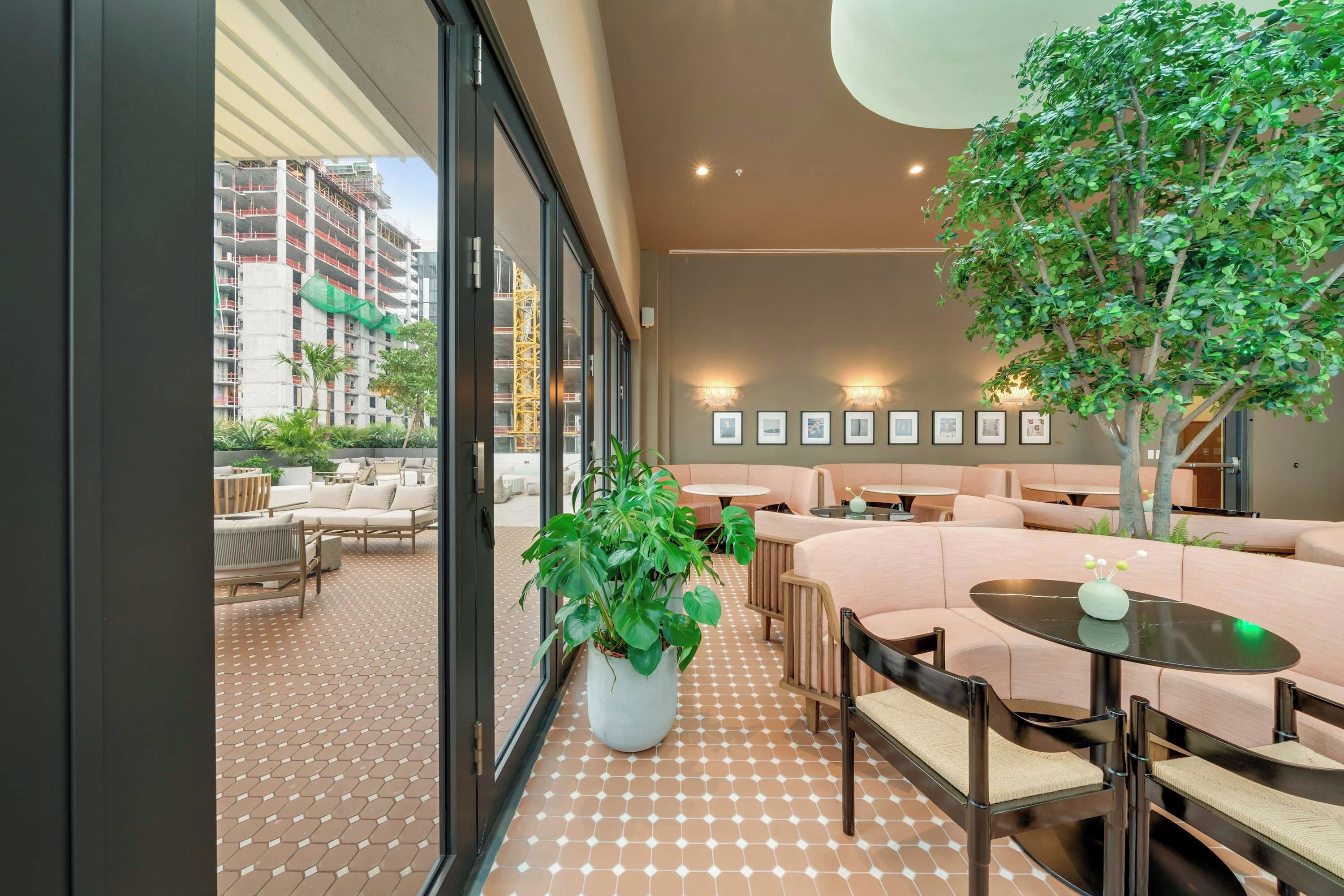 Un espace de détente moderne avec une grande plante en pot, une table ronde et un canapé.
