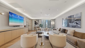 A modern living room with a flat-screen TV, a sofa, a coffee table, and a large window. - Aura Studio, Heart of Miami With Resort Amenities (Miami)